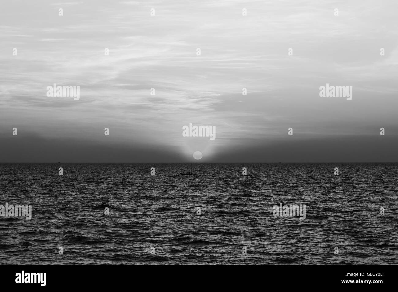 El cielo del atardecer sobre el mar en tonos blanco y negro Foto de stock