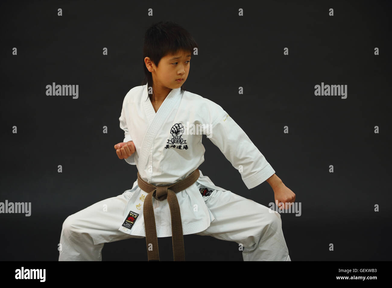 Uniforme de Karate Kid en japonés sobre fondo negro Foto de stock