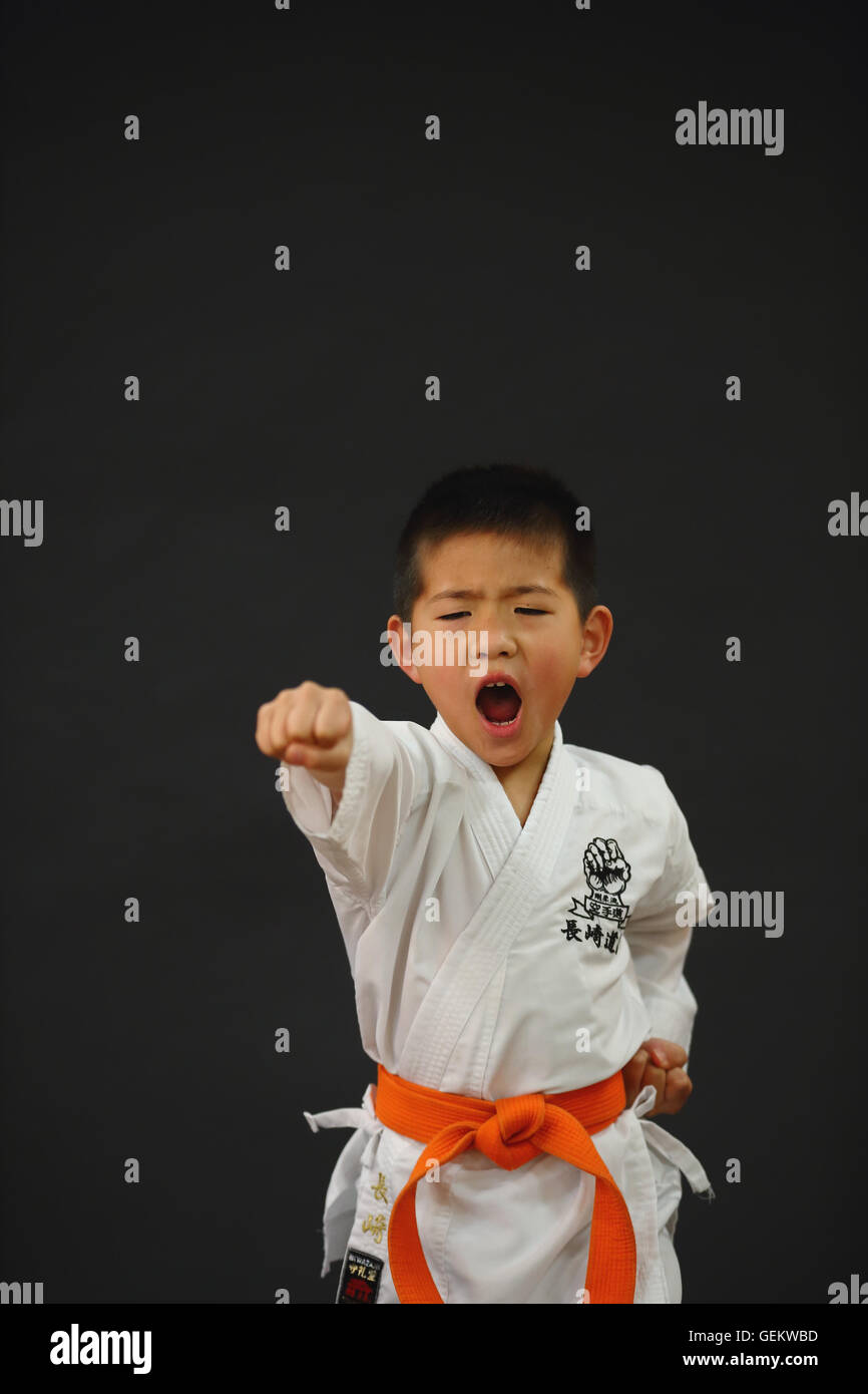 Uniforme de Karate Kid en japonés sobre fondo negro Foto de stock