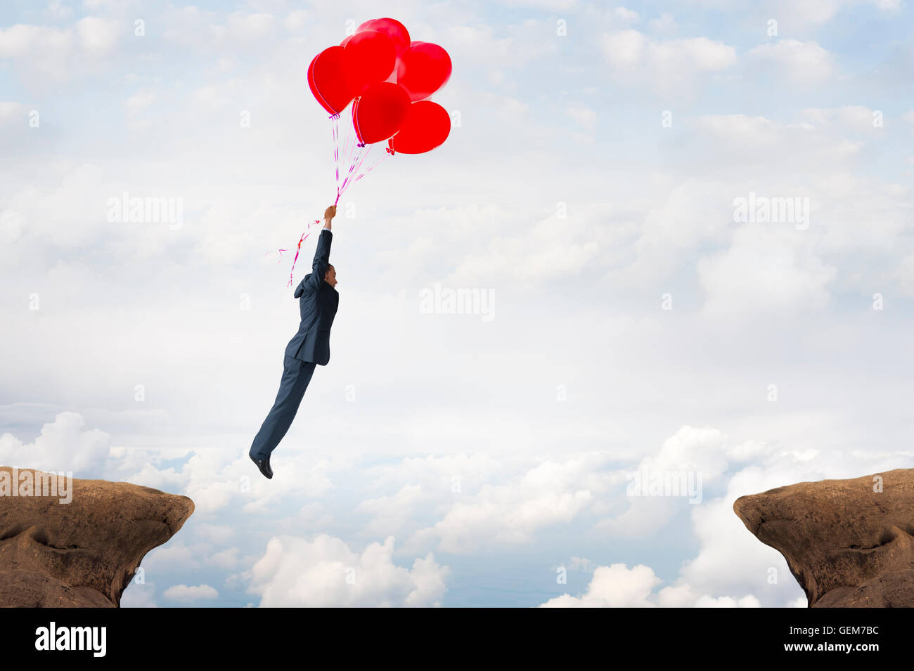 Concepto de brecha de negocios empresario sobrevolando una grieta usando globos de helio Foto de stock