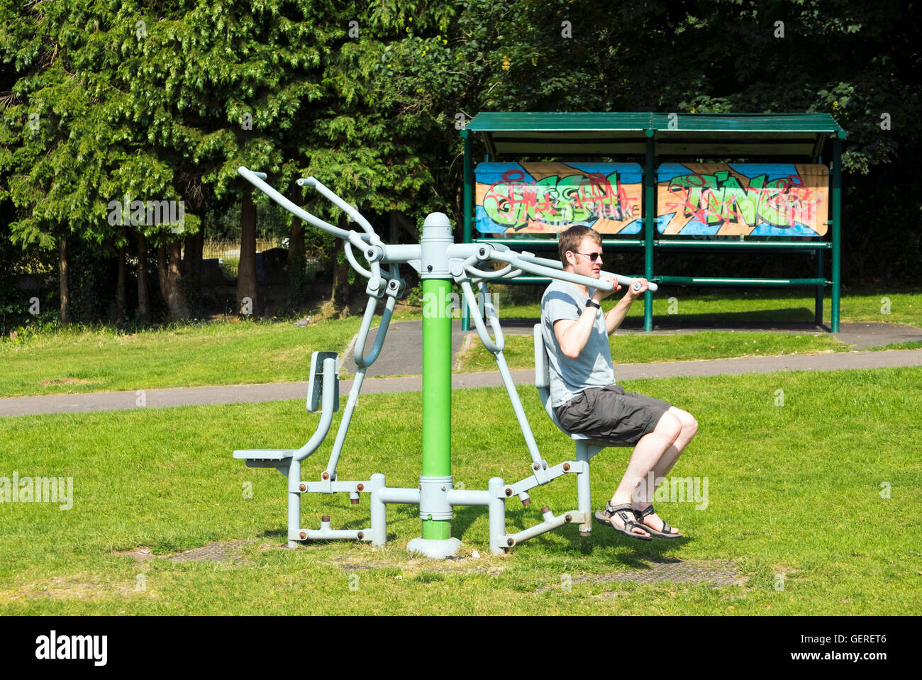 Hombre utilizando equipo de ejercicio al aire libre en el Parque Kingswood, Bristol, Reino Unido Foto de stock