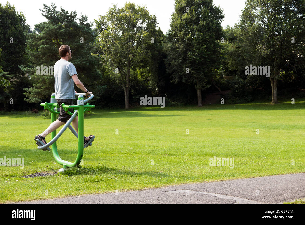 Hombre utilizando equipo de ejercicio al aire libre en el Parque Kingswood, Bristol, Reino Unido Foto de stock