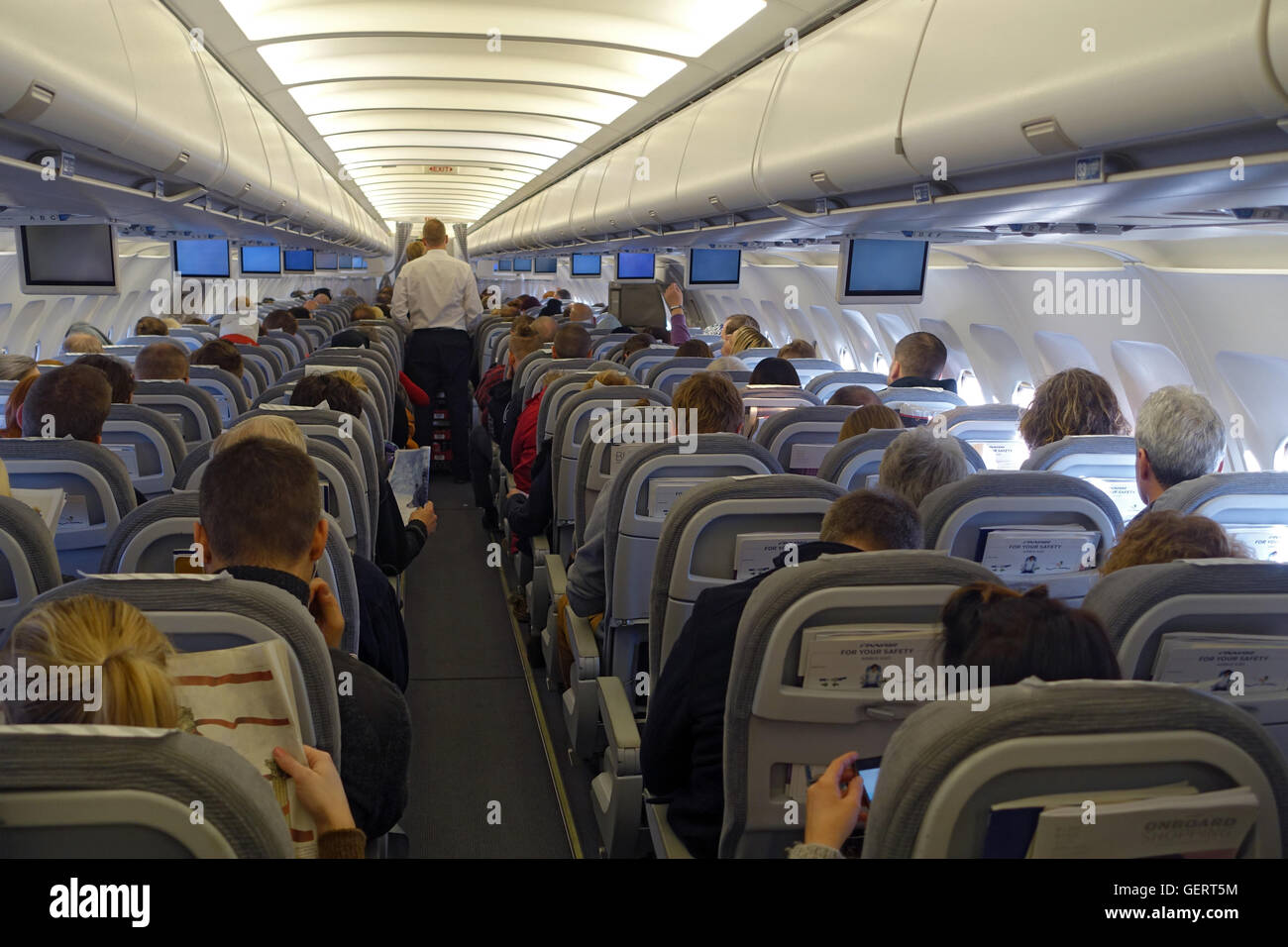 En Vantaa, Finlandia, los pasajeros y la tripulación de cabina en una cabina del avión Foto de stock