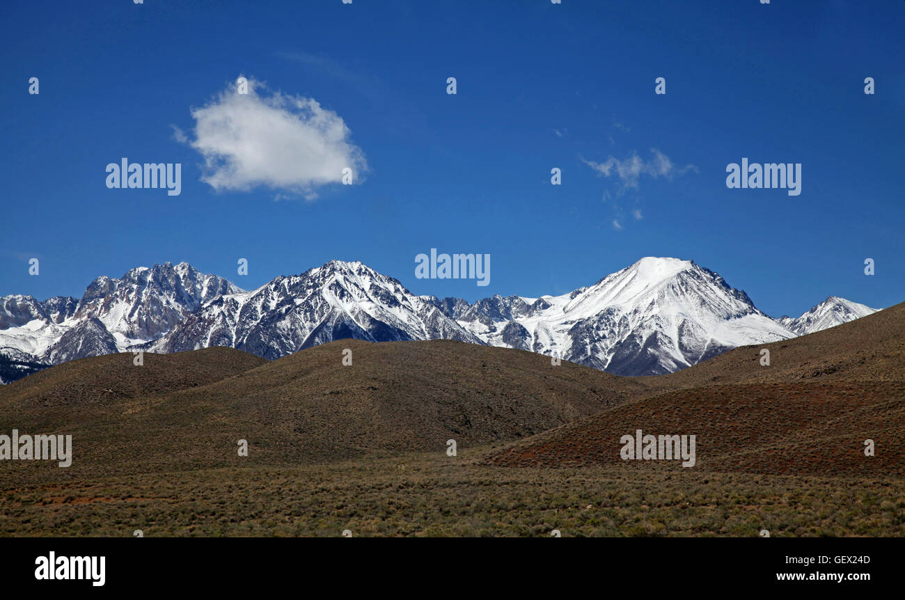 El contraste en la parte oriental de Sierra Nevada: picos nevados y las colinas secas Foto de stock