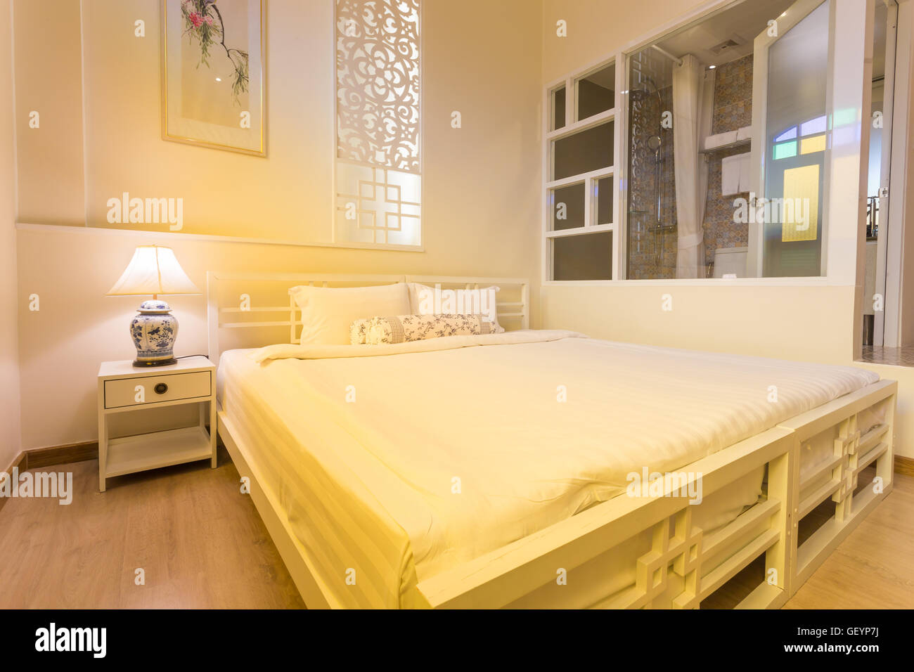 Dormitorio abstractos en cálidos colores claros. Gran cama doble cómoda en una elegante habitación classic Foto de stock