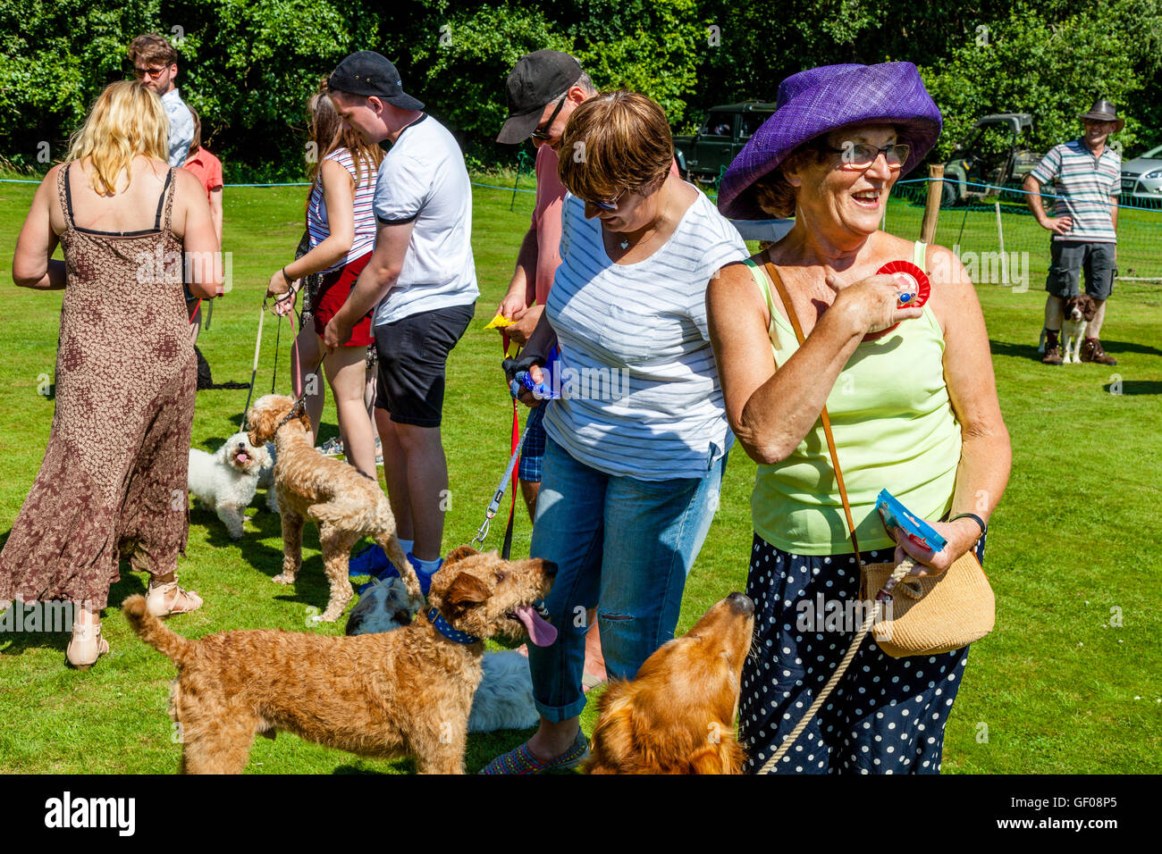 Los dueños de los perros están dados ganadores rosetas por un juez al final de la Exposición Canina, Withyham Fete, Withyham, Sussex, Reino Unido Foto de stock