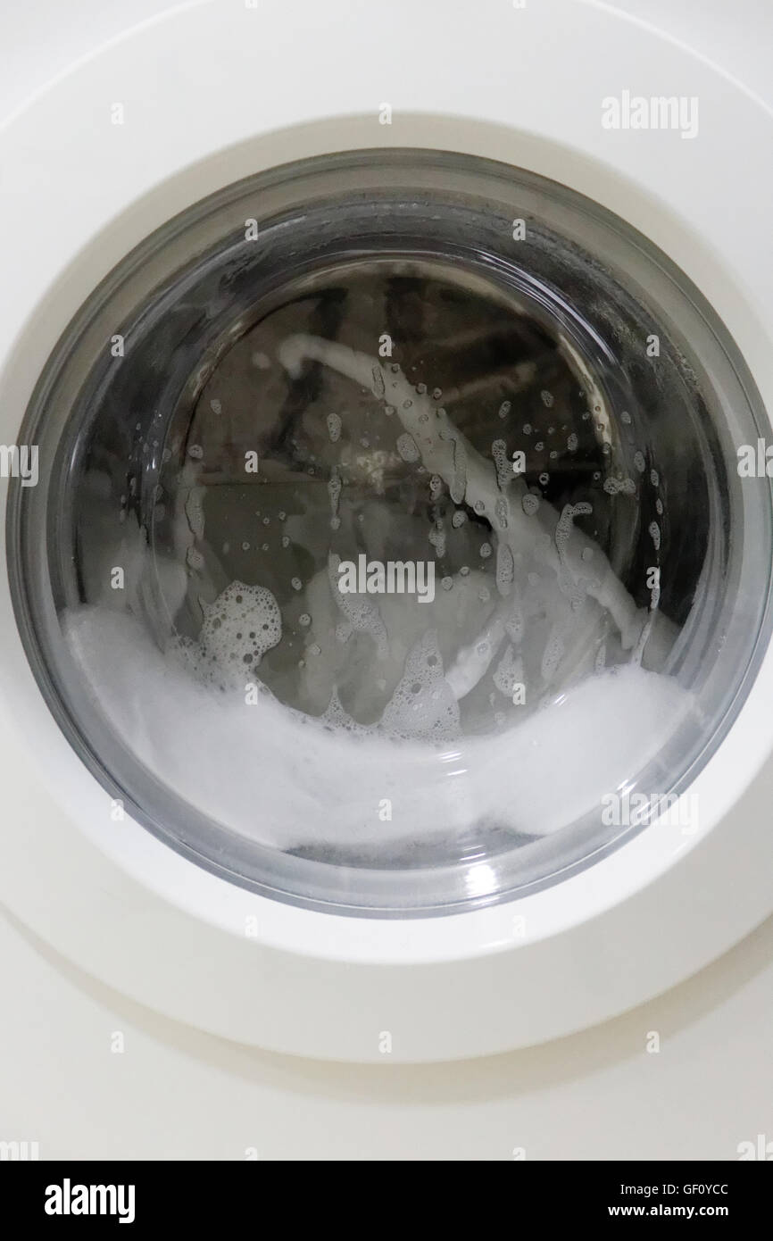 Puerta lavadora blanca, auto-limpieza programa con mucha espuma Fotografía  de stock - Alamy