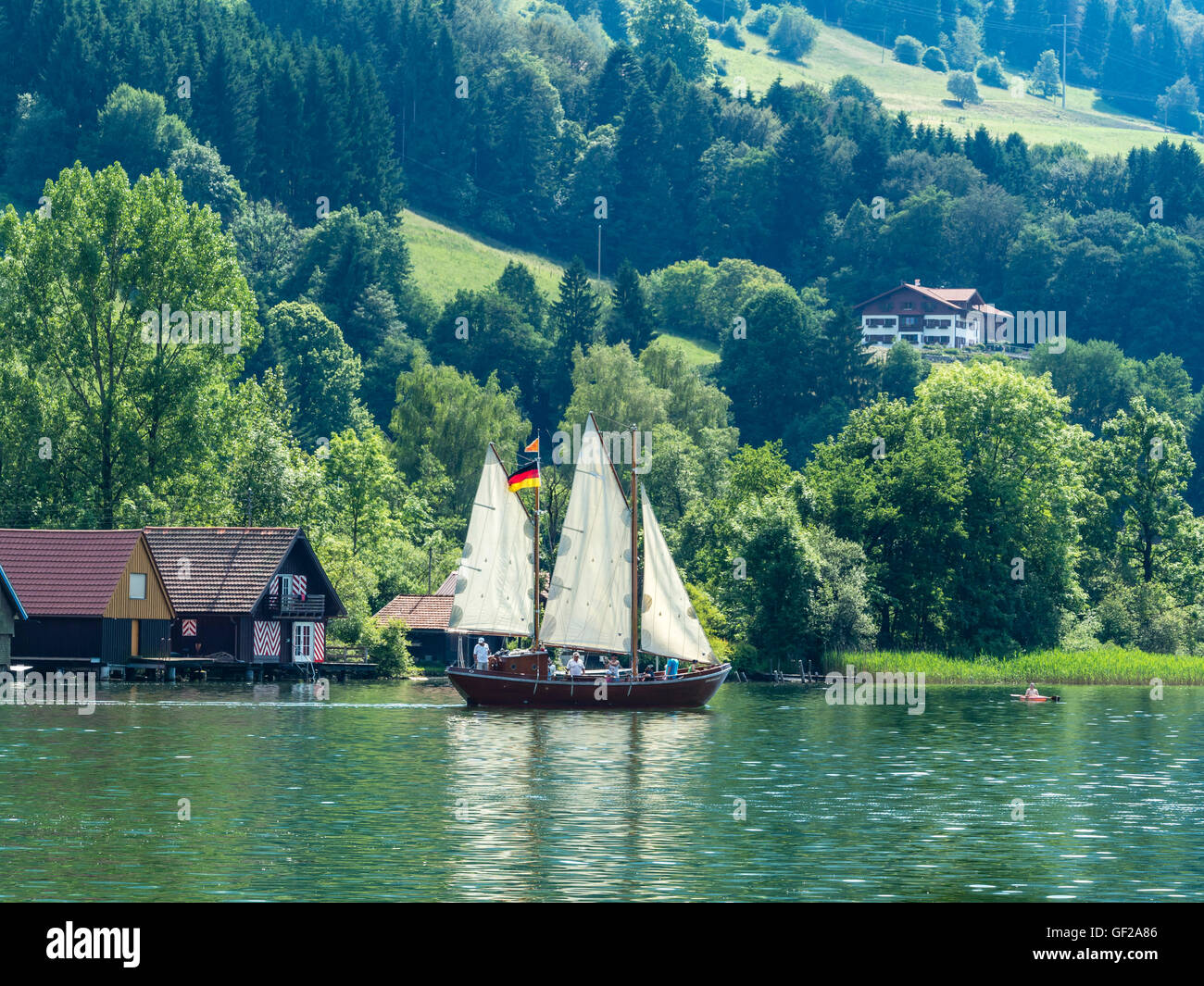 Bote de vela, vela en el lago Alpsee sailss, verano, la gente en el barco, Immenstadt, Allgaeu, Baviera, Alemania Foto de stock