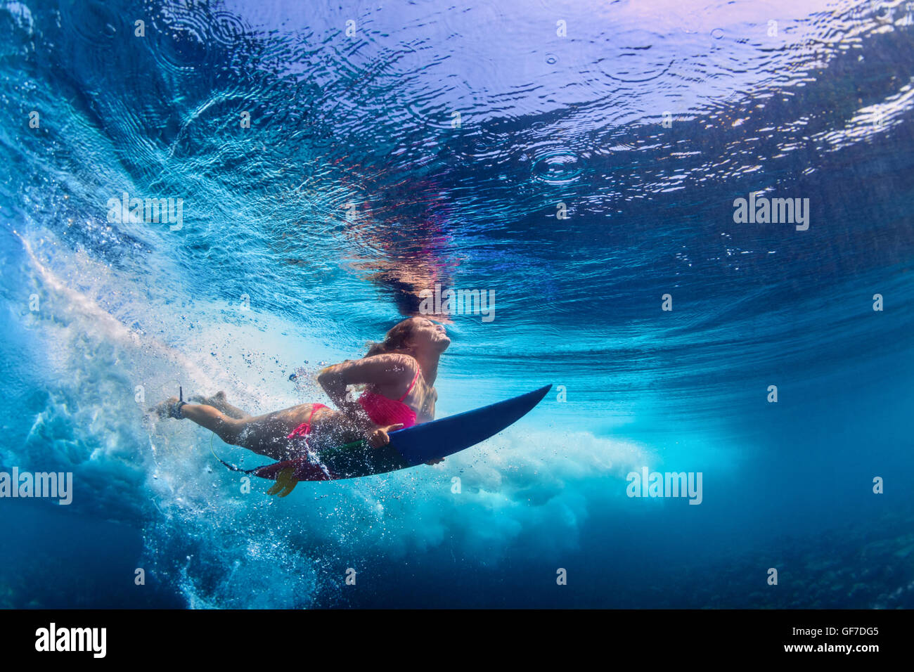 Activa joven vestida de bikini en acción - surfer con surf buceo en submarinos gran ola del océano atlántico. Foto de stock