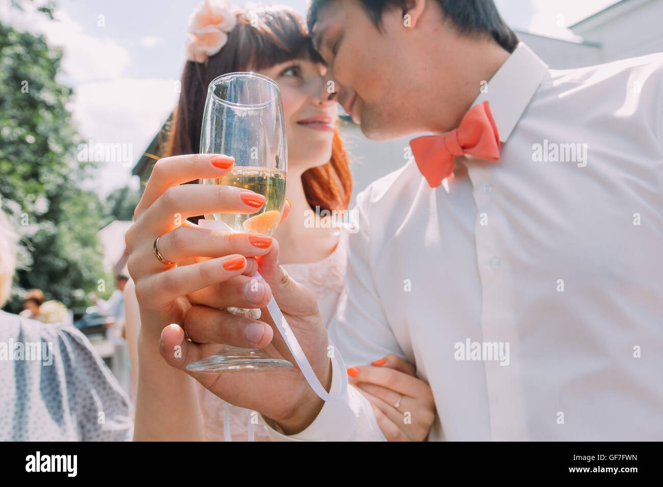 La novia y el novio beber champán en el exterior después de una ceremonia de boda Foto de stock