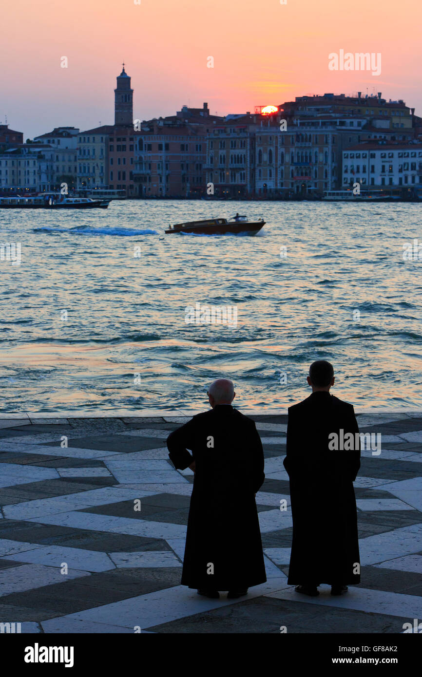 Dos monjes benedictinos de San Giorgio Maggiore en Venecia, Italia, disfrutando de la puesta de sol Foto de stock