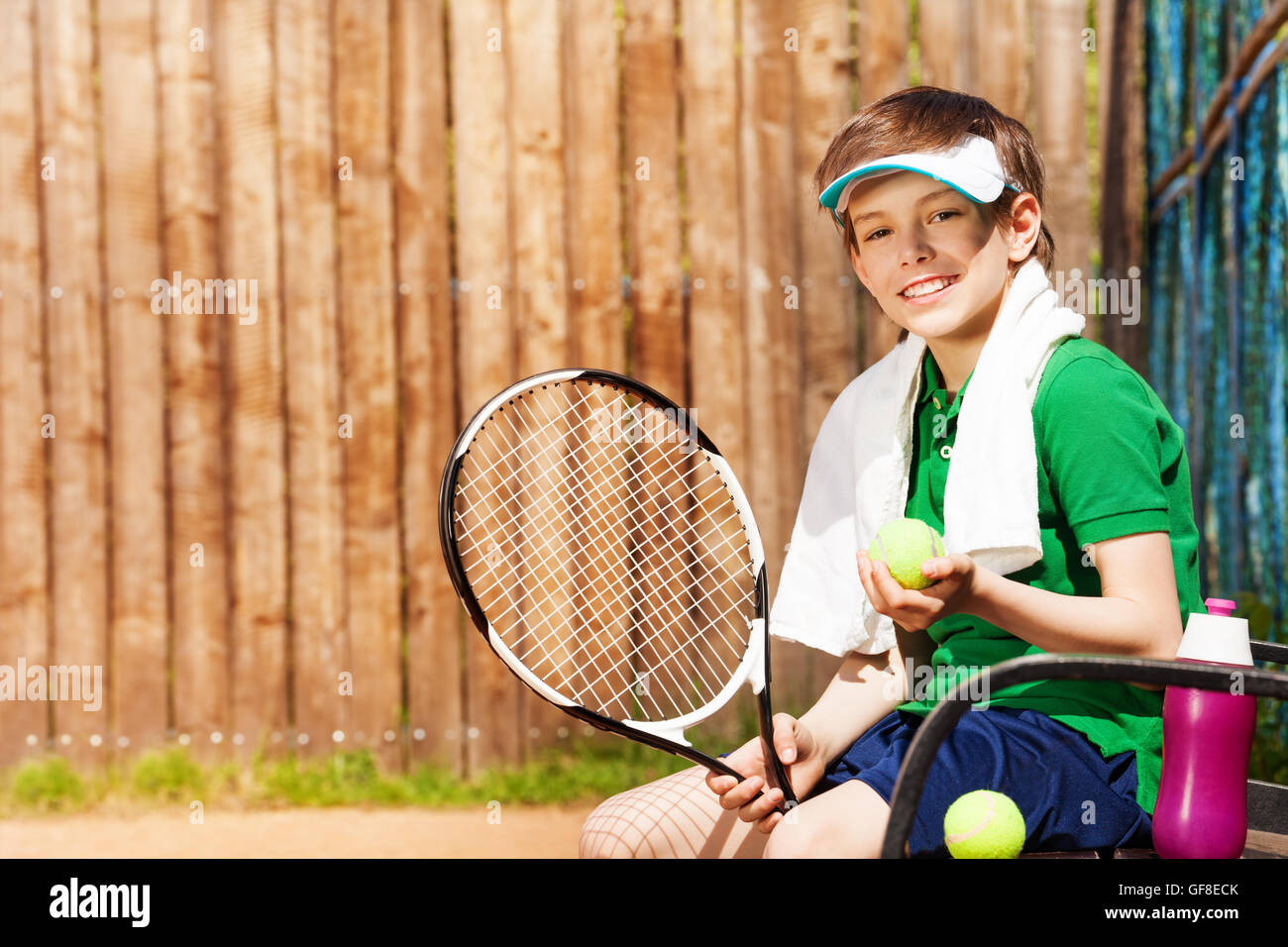 Joven Jugador de tenis sentado en un banco después de juego Foto de stock