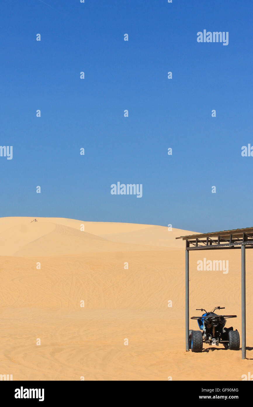 Motor quad en el desierto de dunas de arena blanca. Foto de stock