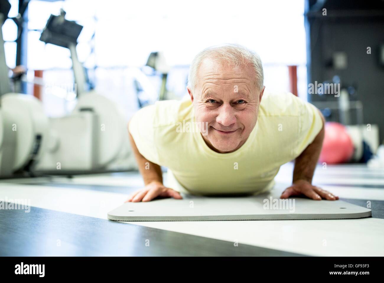 Liberados de la propiedad. Modelo liberado. Retrato senior hombre haciendo ejercicio en el gimnasio y sonriente. Foto de stock