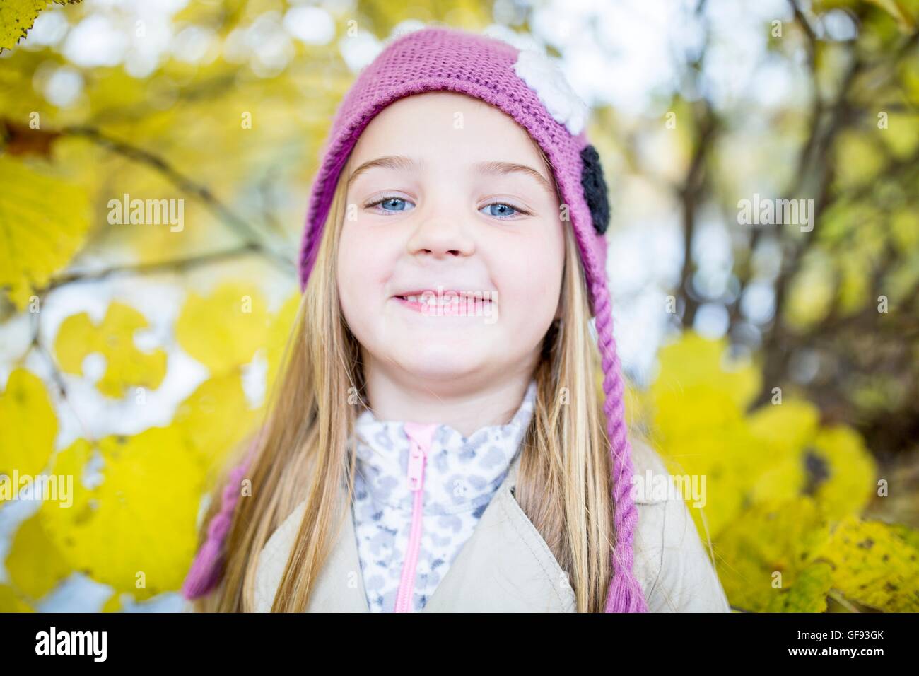 Modelo liberado. Chica rubia vistiendo woolly hat y sonriente, primer plano, retrato. Foto de stock