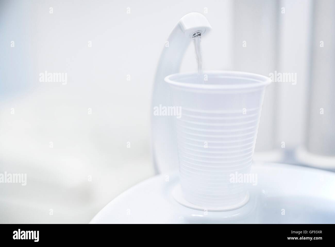Dispensador de agua con vaso desechable en dentista clínica. Foto de stock