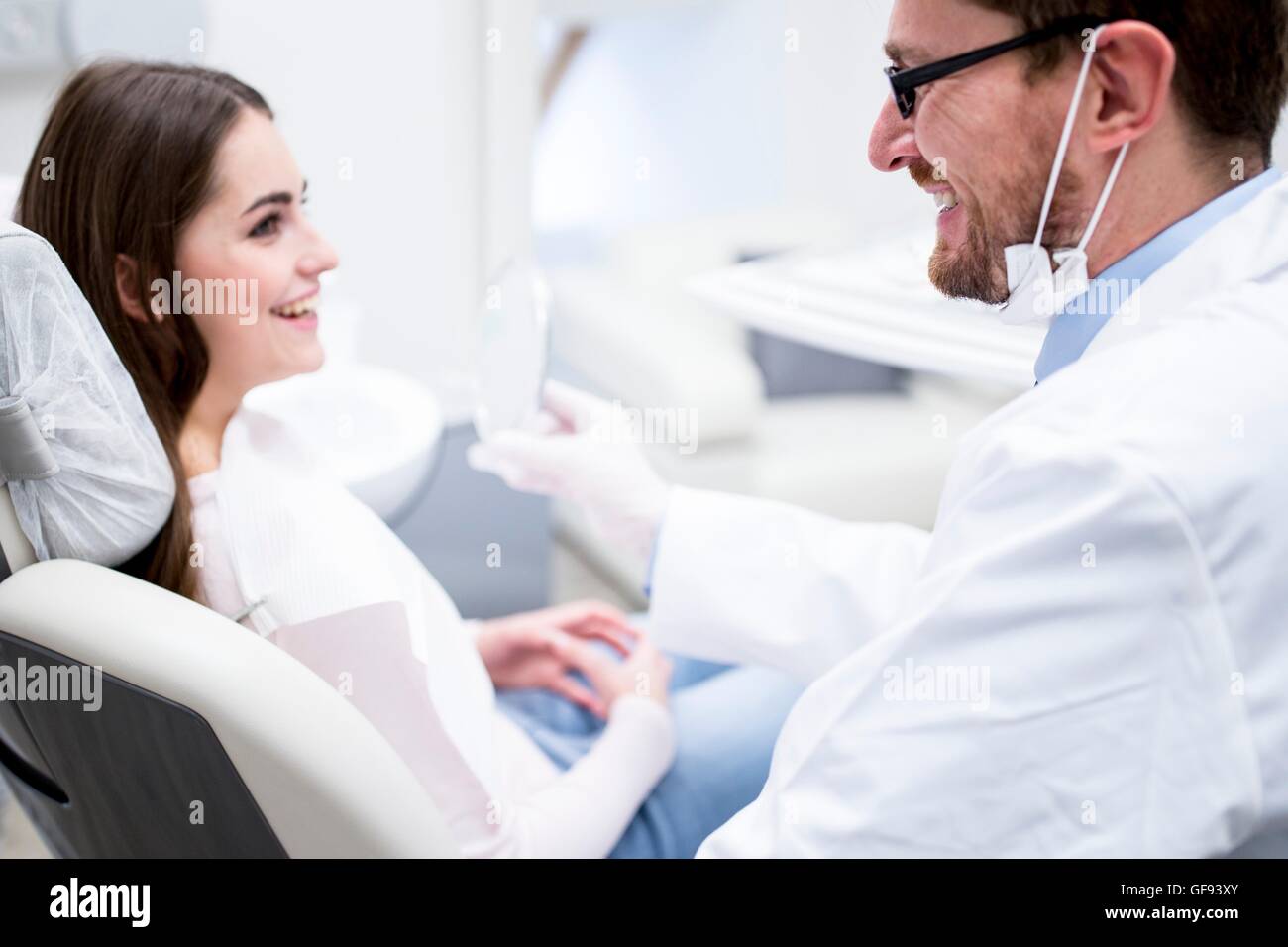 Modelo liberado. Dentista y paciente dentista sonriendo en clínica. Foto de stock