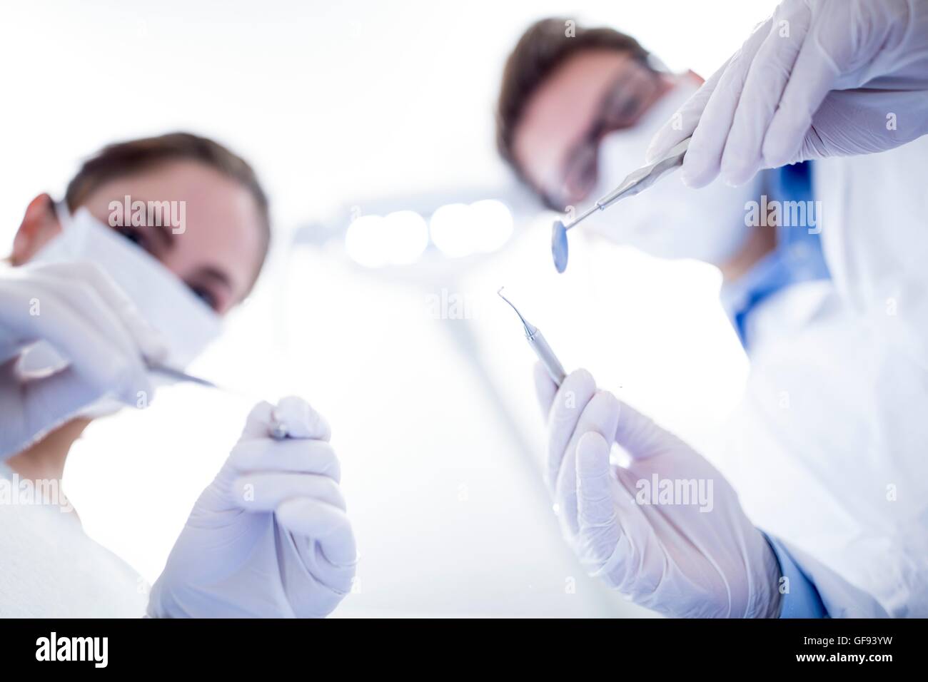 Modelo liberado. Dentista y asistente dental holding espejo angulado. Foto de stock