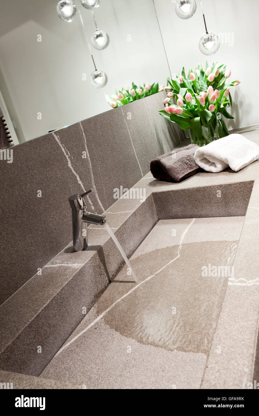 Lavabo de piedra gris con un diseño moderno, baño Foto de stock
