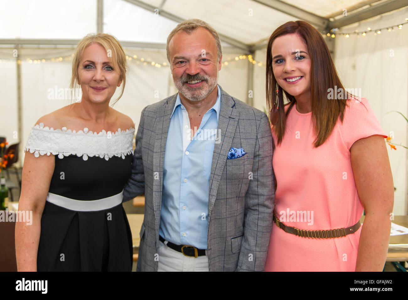 Ahakista, Irlanda. El 29 de julio, 2016. Graham Norton organizó un concurso en ayuda al desarrollo de la Asociación Comunitaria Ahakista sitio en Ahakista, West Cork por cuarto año consecutivo el viernes por la noche. El concurso fue parte de la anual regata Ahakista & Festival. Foto con Graham antes del evento fueron Maureen Arundel de Ahakista y Deirdre Keohane de Bantry. Crédito: Andy Gibson/Alamy Live News Foto de stock