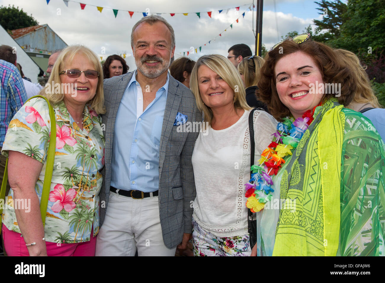 Ahakista, Irlanda. El 29 de julio, 2016. Graham Norton organizó un concurso en ayuda al desarrollo de la Asociación Comunitaria Ahakista sitio en Ahakista, West Cork por cuarto año consecutivo el viernes por la noche. El concurso fue parte de la anual regata Ahakista & Festival. Foto con Graham antes del evento fueron Marie Ryan, Straffan, Co. Kildare; Helen O'Brien, Tipperary, y Sinead Cristiano, Straffan, Co. Kildare. Crédito: Andy Gibson/Alamy Live News Foto de stock