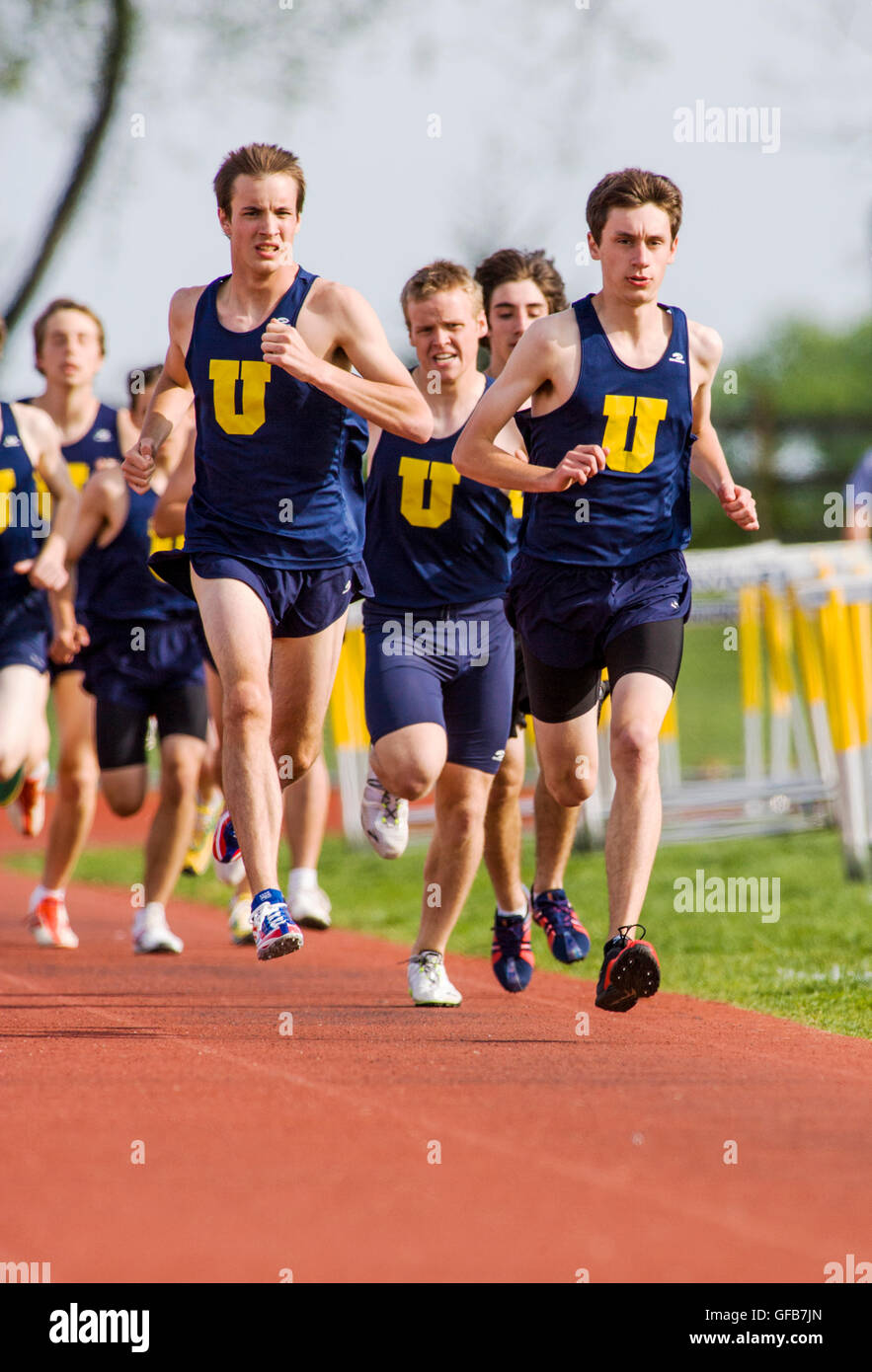 Los corredores compiten en la pista durante una high school Track & Field satisfacer. Foto de stock