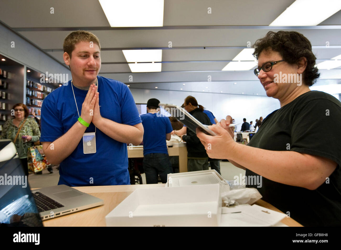 Un empleado de Apple store (L), la camisa azul gestos como cliente (R) se  desajusta su nuevo iPad Fotografía de stock - Alamy