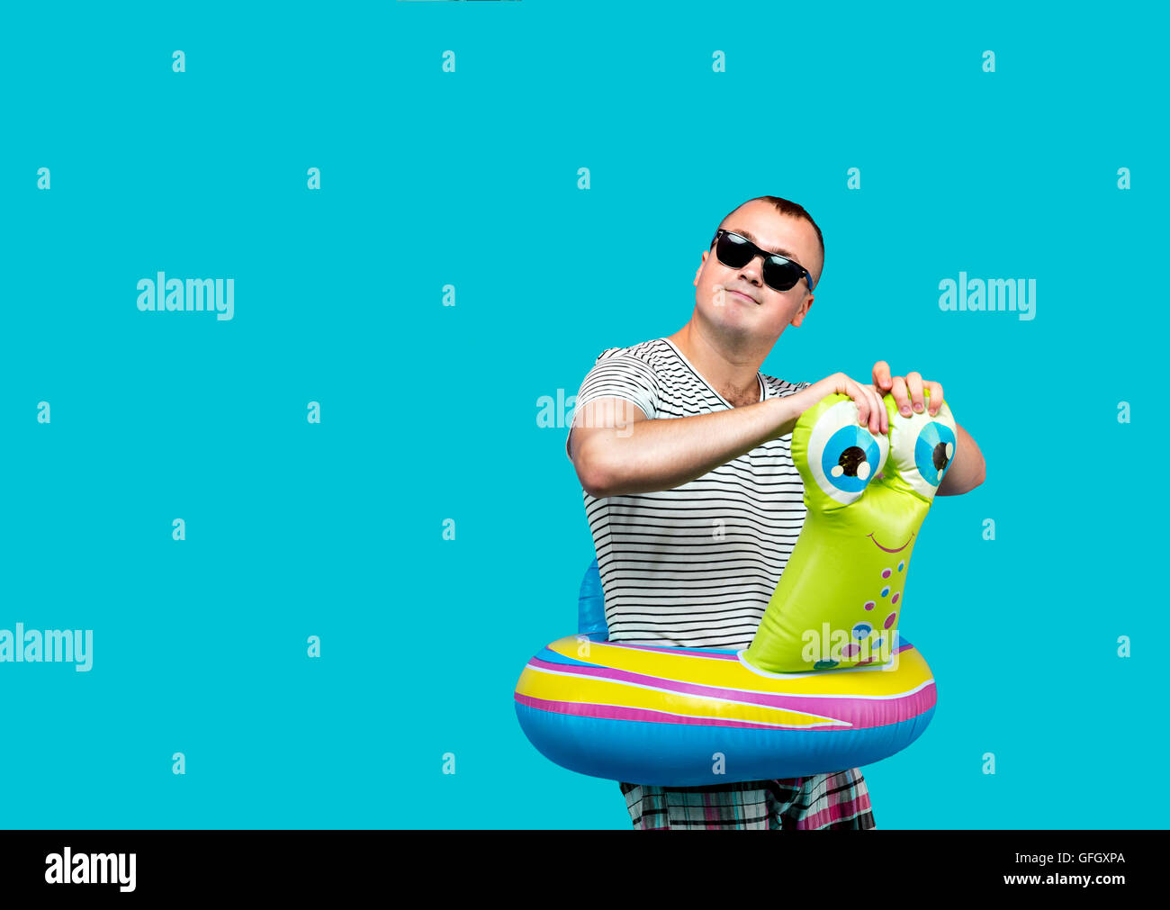 Hombre con gafas de sol, camisa a rayas, nadar en forma de caracol mirando  lejos, fondo azul. Concepto de vacaciones Fotografía de stock - Alamy