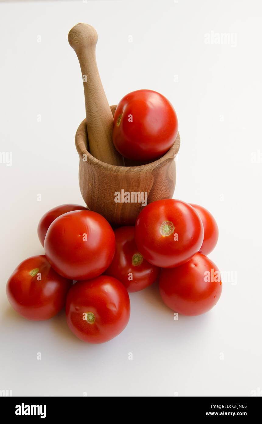 Los tomates apiladas contra un mortero aislado sobre un fondo blanco tierra Foto de stock
