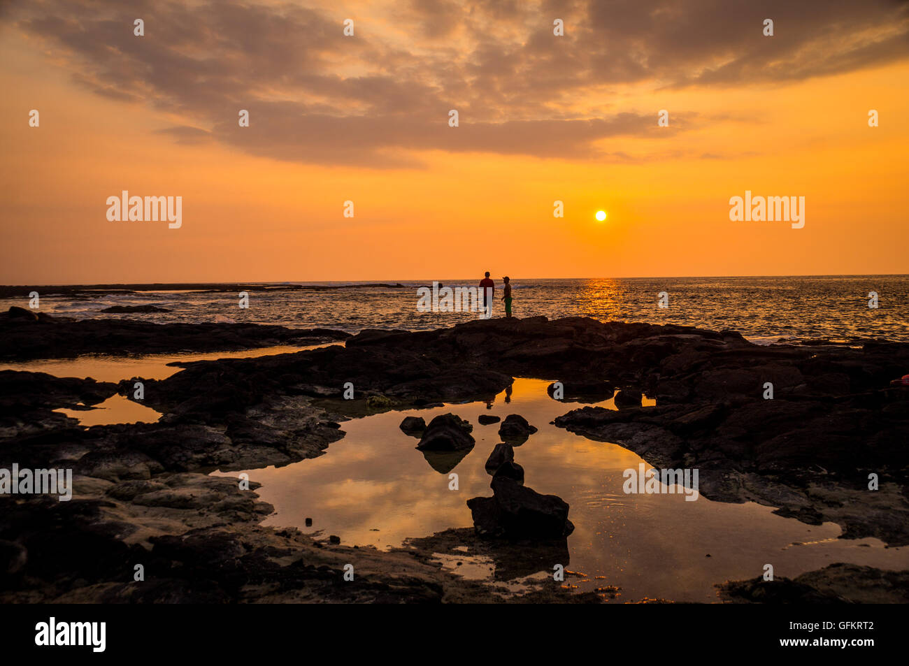 Dos personas mirando atardecer en dos pasos, Big Island, Hawai. Dos paso es famoso por su excelente buceo y snorkeling y su col Foto de stock