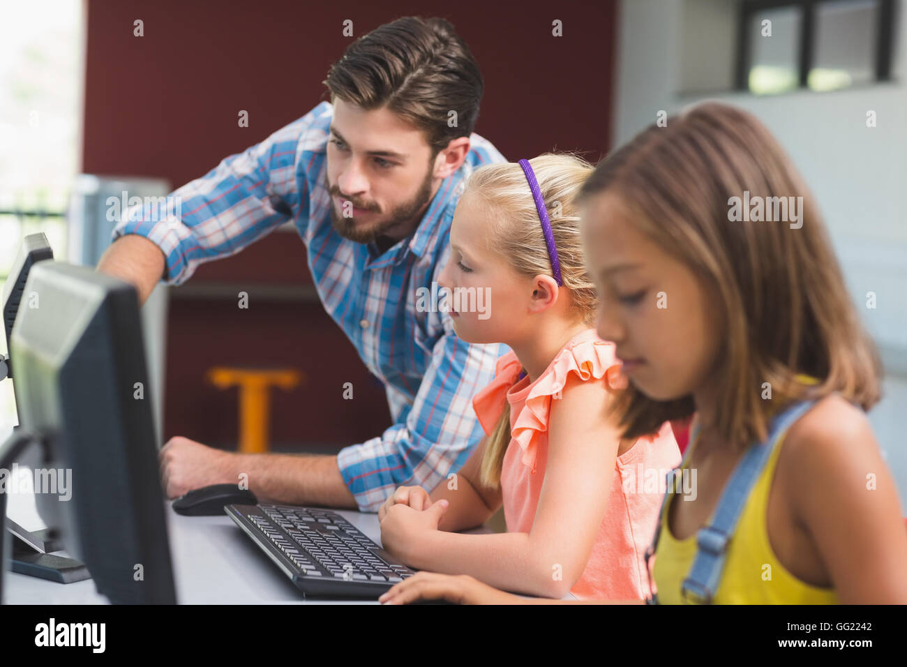 Profesor ayudar a alumnas en el aprendizaje de equipo Foto de stock