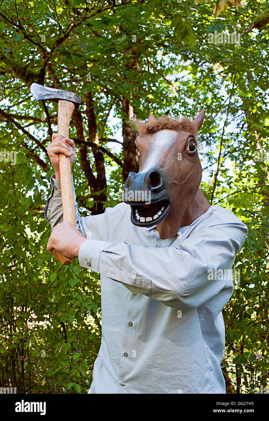 Un hombre que llevaba una máscara de caballo balancea un hacha Fotografía  de stock - Alamy