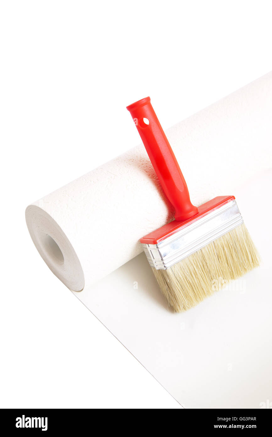 Cepillo y rollo de papel tapiz aislado sobre fondo blanco. Foto de stock