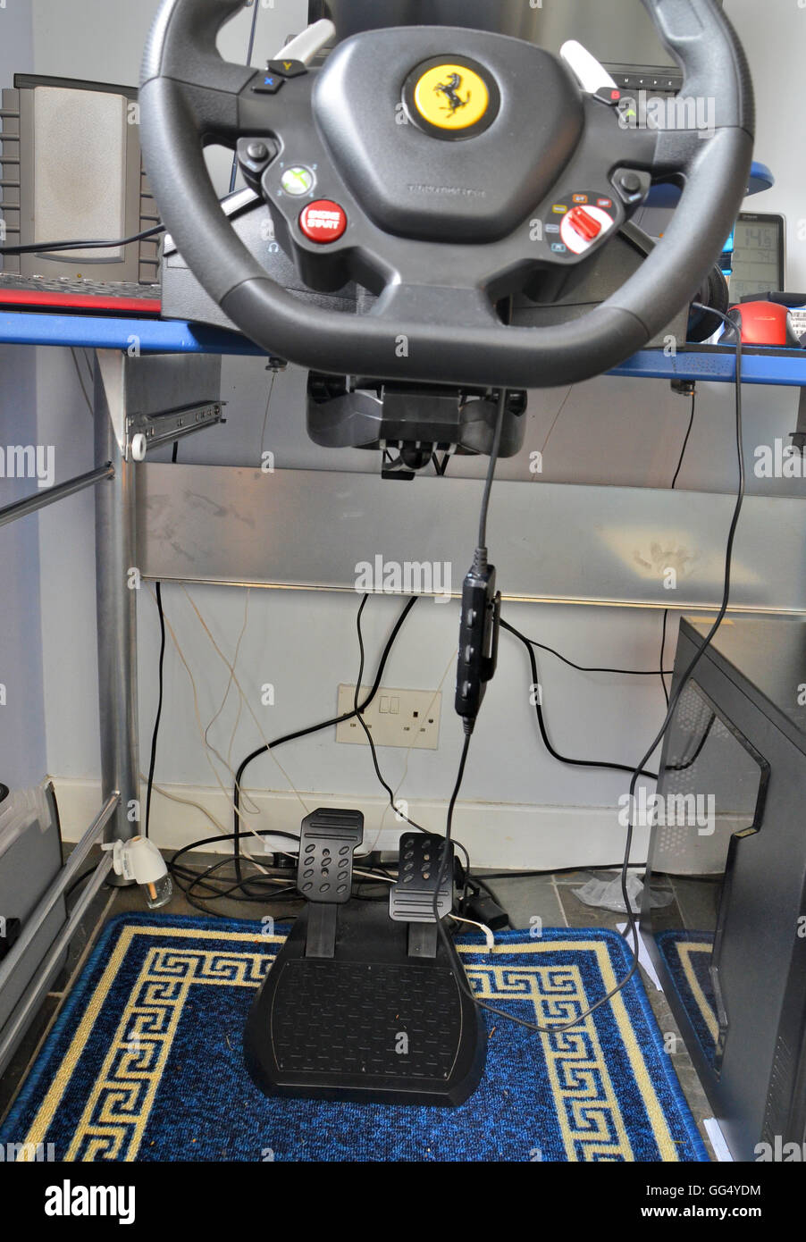 La plataforma de juegos de ordenador - incluye volante montado en el escritorio y los pedales del freno y acelerador y altavoces. Foto de stock