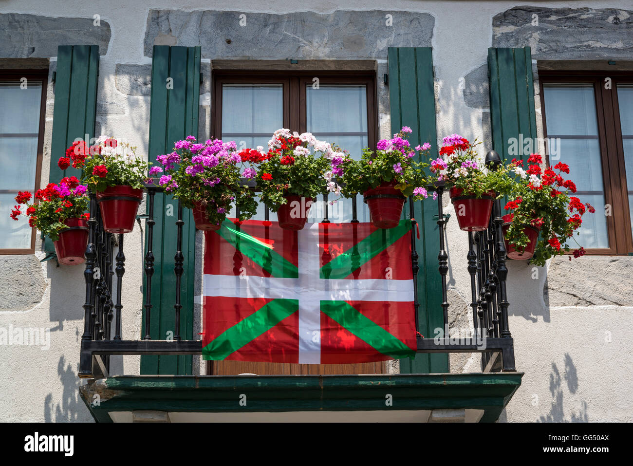 Casa con balcón y flores con la bandera del País Vasco, Lesaka, Navarra, Norte de España Foto de stock