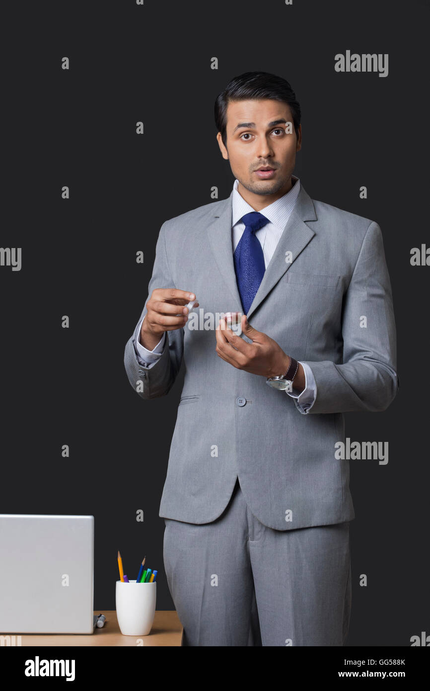Retrato de empresario indio celebración bálsamo labial pote en Office Foto de stock