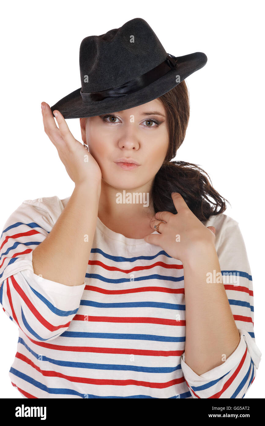 Grave buxomy chica con un sombrero sobre un fondo blanco. Foto de stock