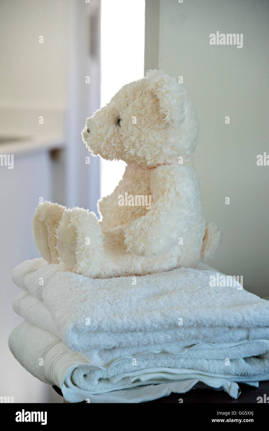 Oso de peluche en la toalla en el baño. Foto de stock