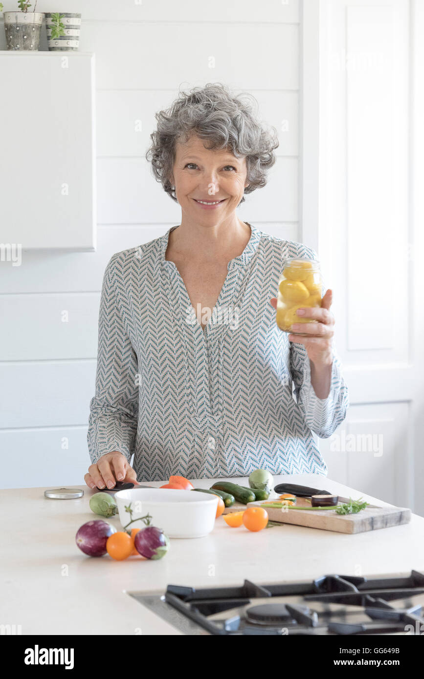Mujer alegre y preparar la comida en la cocina Foto de stock