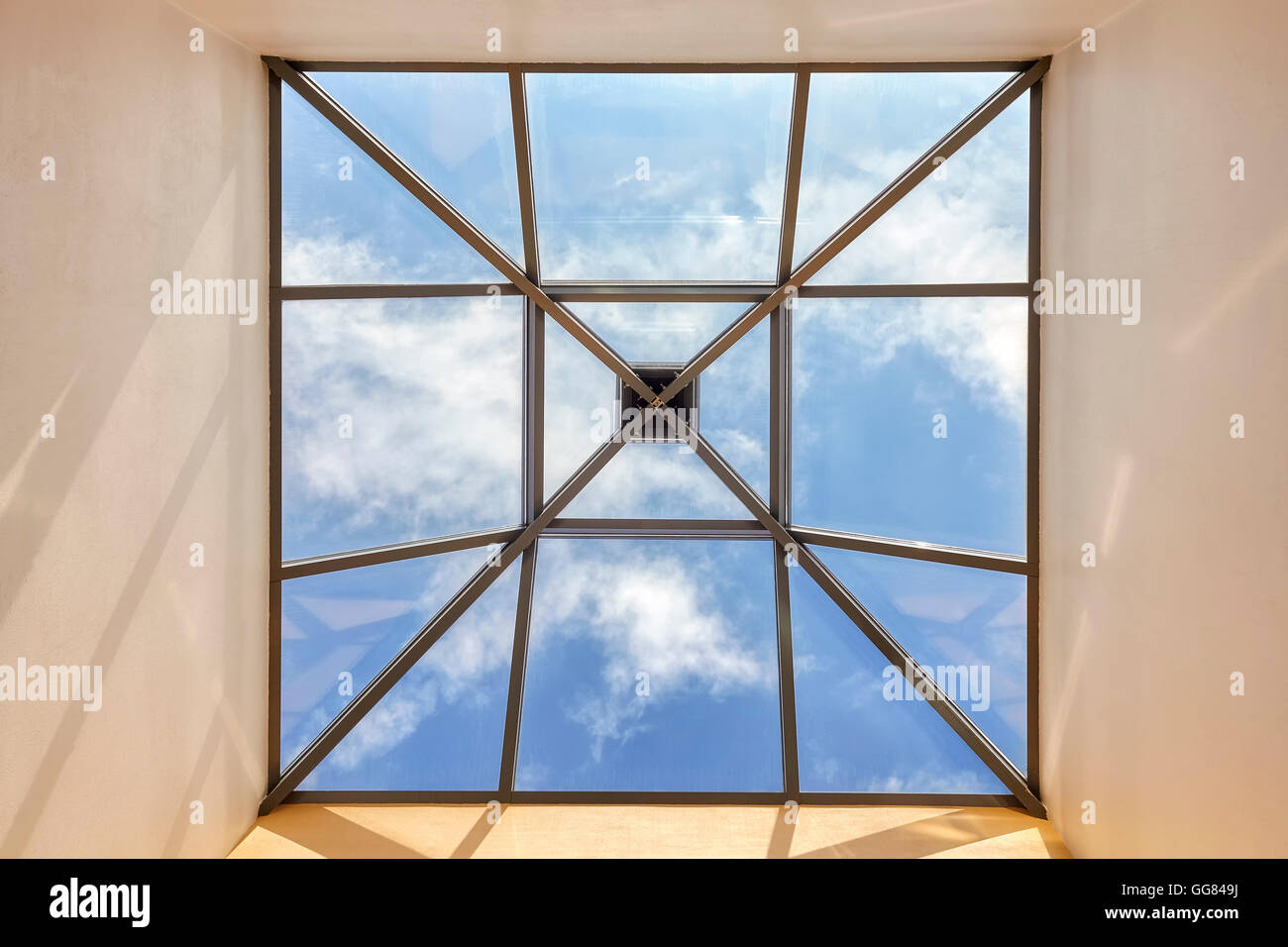 Ventana en el techo con cielo azul y nubes, imagen conceptual. Foto de stock
