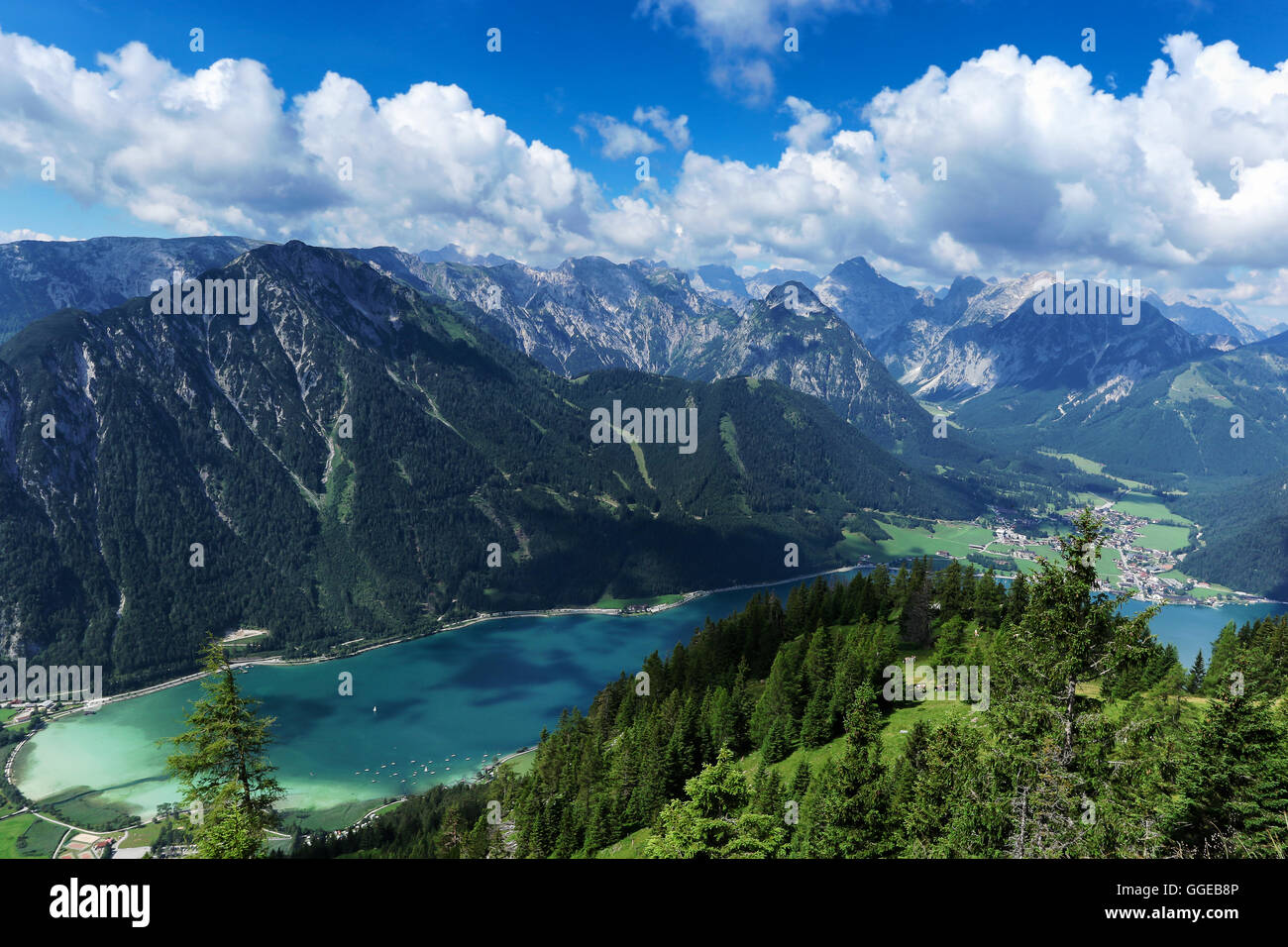Vista aérea de Blue Mountain Lake entre boscosas montañas rocosas. Achensee, Austria, Tirol Foto de stock
