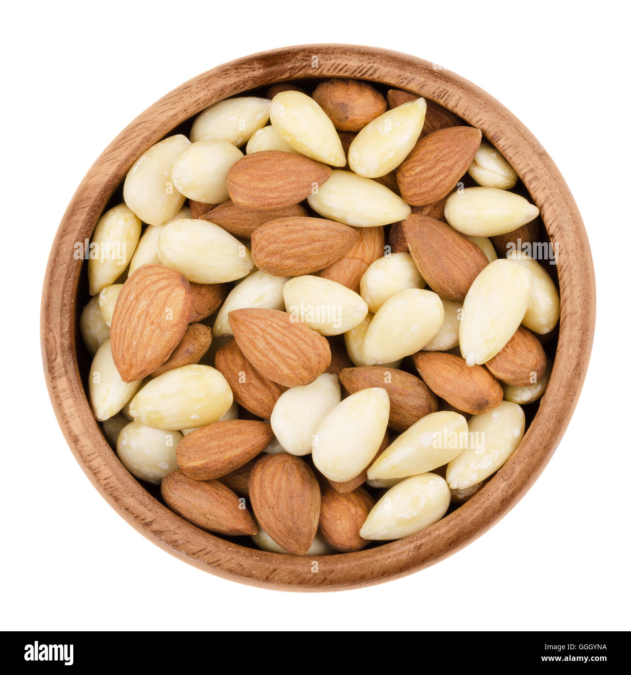 Peladas y almendras peladas en un recipiente sobre un fondo blanco. Las materias semillas comestibles hay tuercas, botánicamente son drupas. Foto de stock