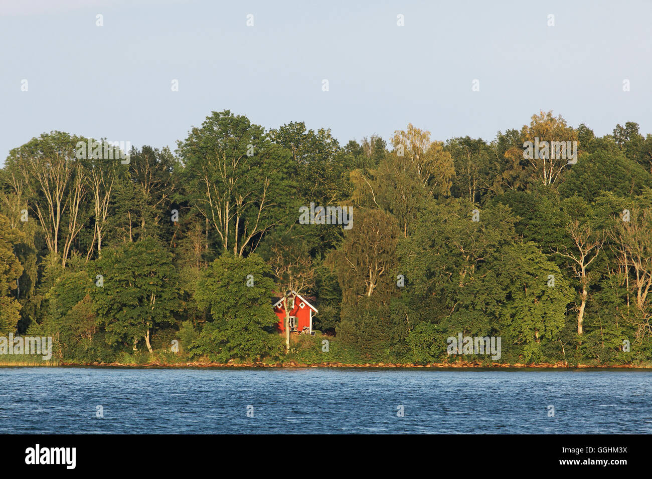 Casa de vacaciones en rojo en el borde del lago Vaettern, Suecia Foto de stock