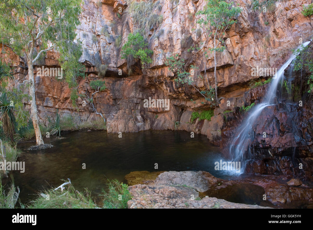 Lily Creek Laguna con cascada y pared de roca roja, cerca de Kununurra, Australia Occidental, Australia Foto de stock