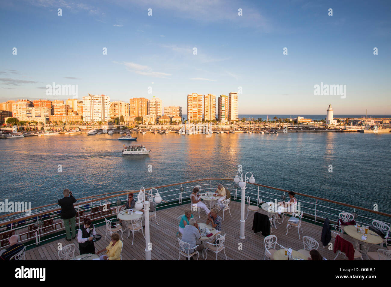 Los pasajeros de disfrutar de una cena fuera de Lido Cafe a bordo del barco crucero MS Deutschland (Peter Deilmann Reederei) al atardecer, Málaga, anda Foto de stock