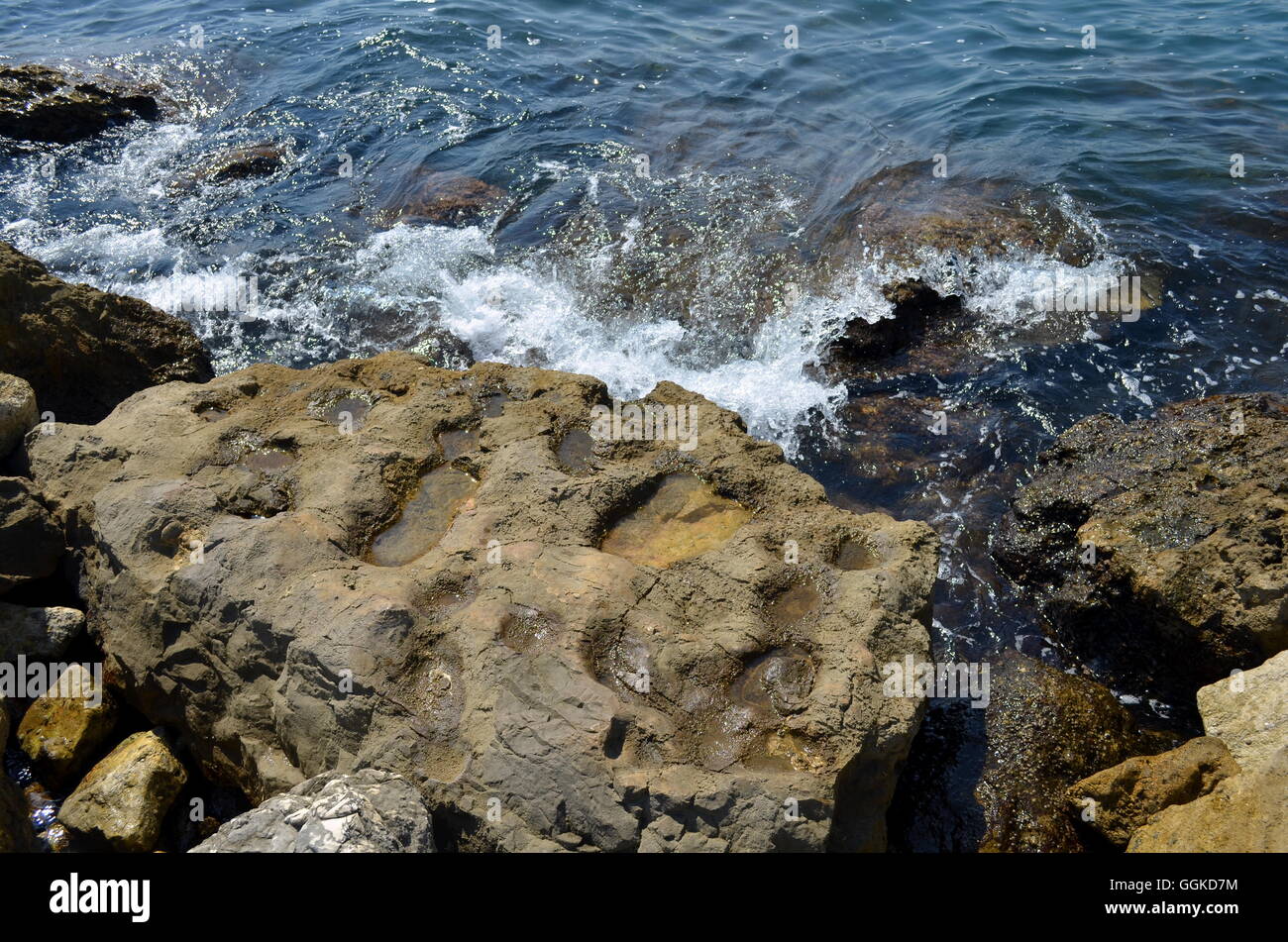 Las olas que rompen en una playa rocosa del mar mediterráneo Foto de stock