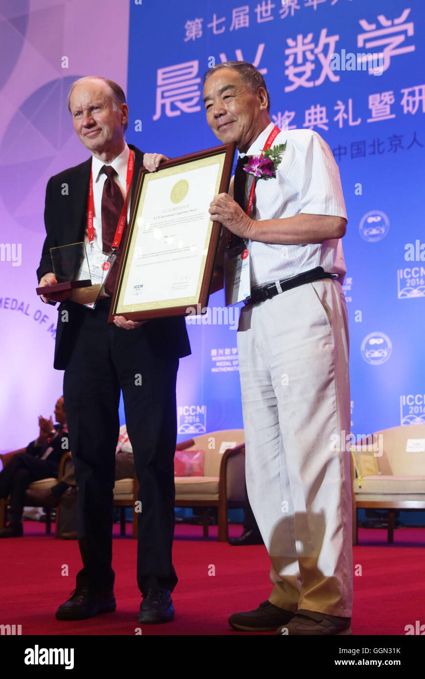 (160806) -- BEIJING, Agosto 6, 2016 (Xinhua) -- Bjorn Engquist (L), la Presidencia de la computación y matemáticas aplicadas en la Universidad de Texas en Austin, recibe el Premio de Cooperación Internacional ICCM en la ceremonia de inauguración del 7º Congreso Internacional de Matemáticos chinos (ICCM) en Beijing, capital de China, el 6 de agosto, 2016. El congreso es un evento trienal que reúne a chinos de ultramar y matemáticos para la discusión de la evolución de las matemáticas. (Xinhua/Cai Yang)(wjq) Foto de stock