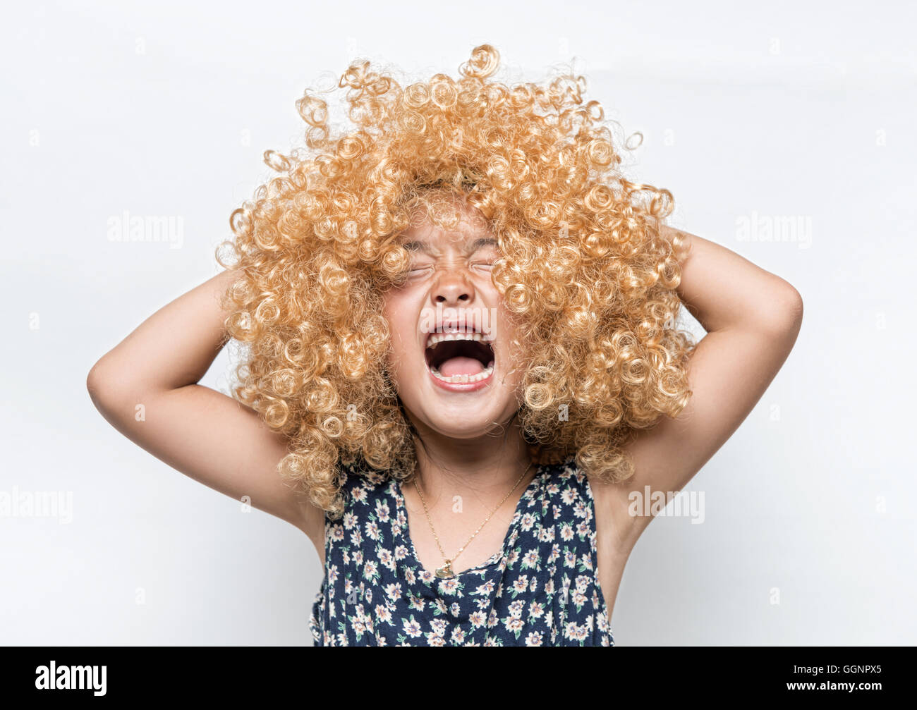Llevaba una peluca rubia y divertida expresión facial muchacha asiática Foto de stock