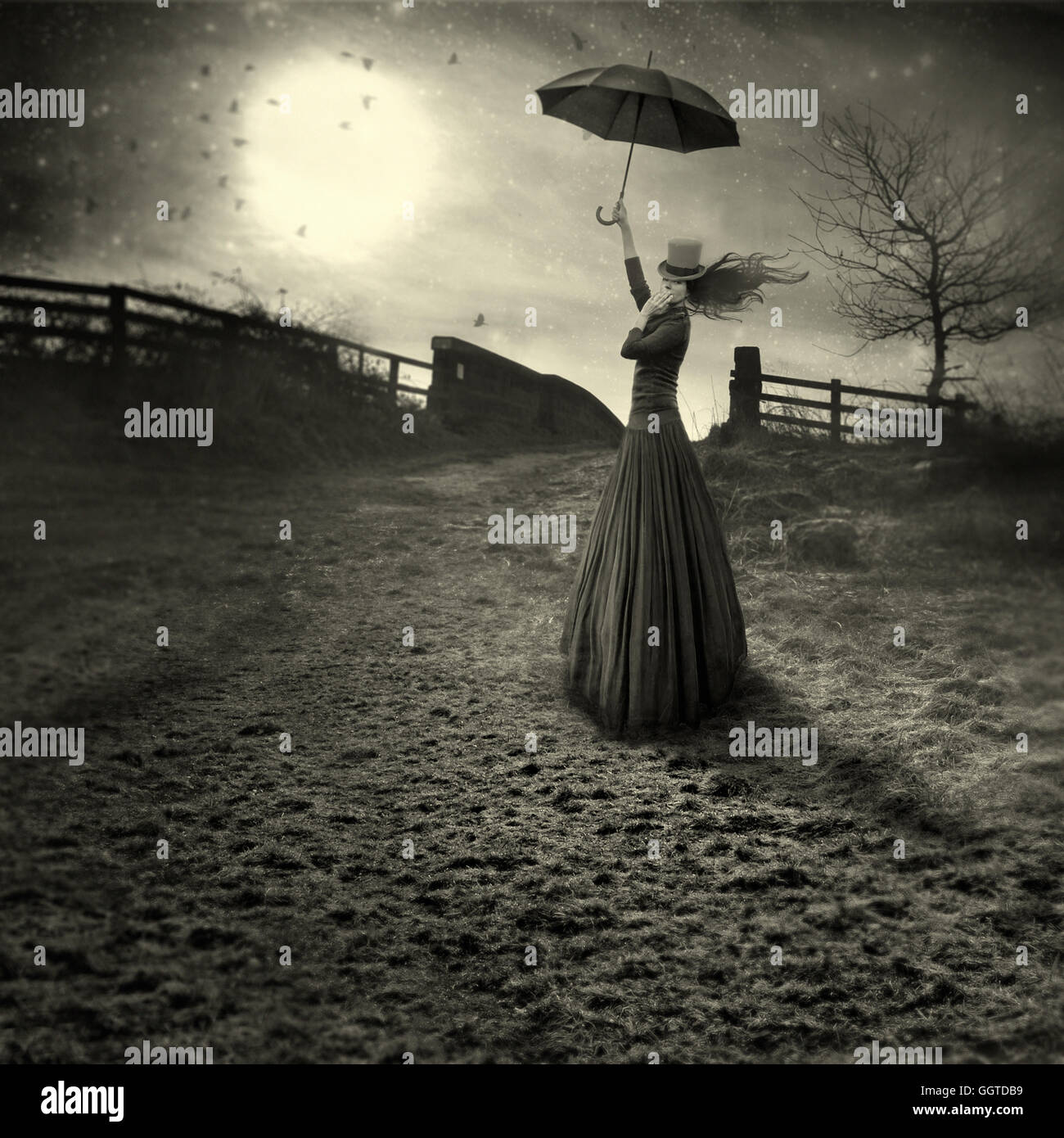 Mujer joven como marry Poppins con sombrilla de pie en los campos Foto de stock