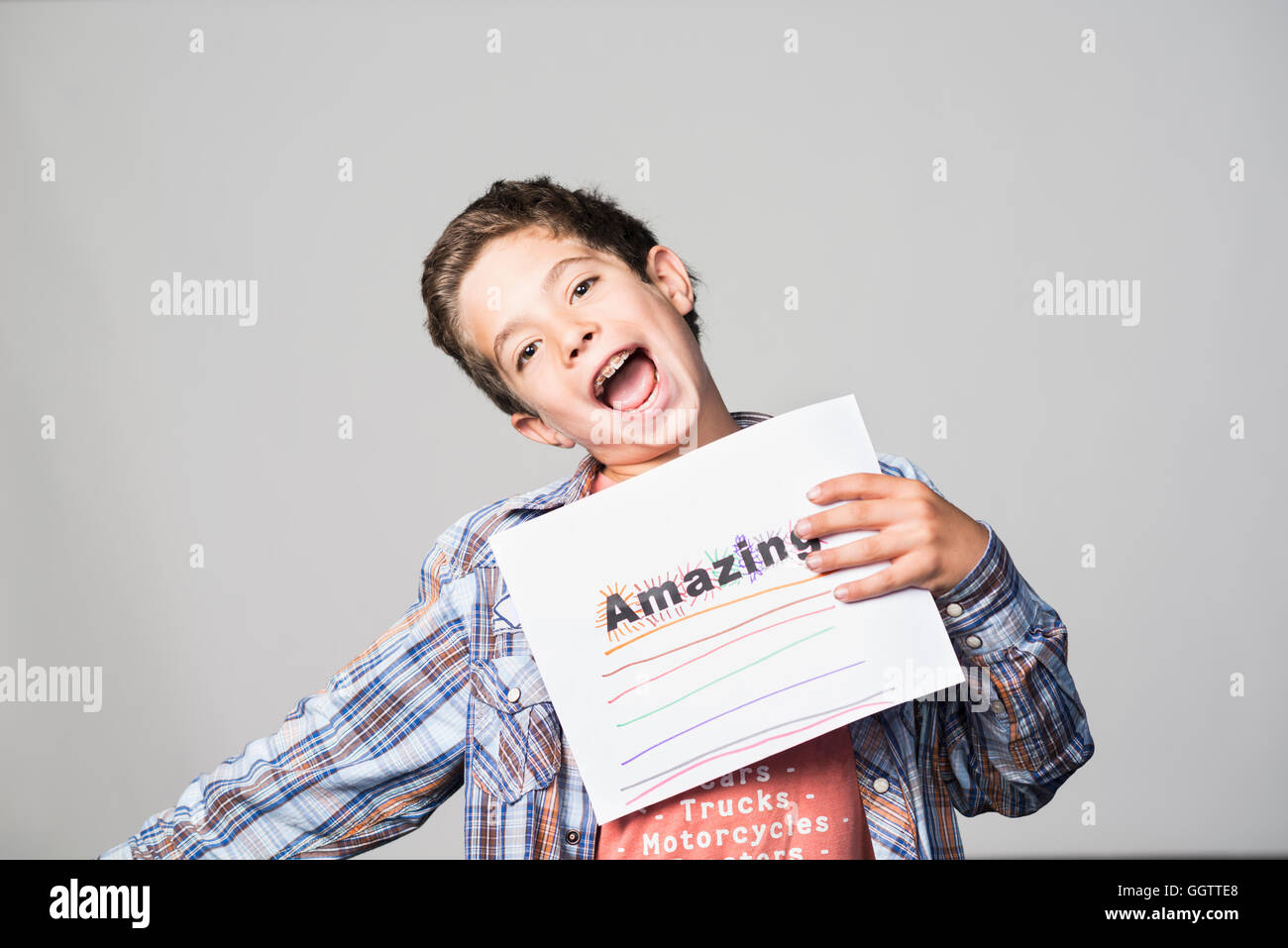 Orgullosa raza mixta niño sosteniendo impresionante cartel Foto de stock